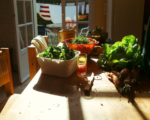 Fresh vegetables and water on a wooden kitchen table