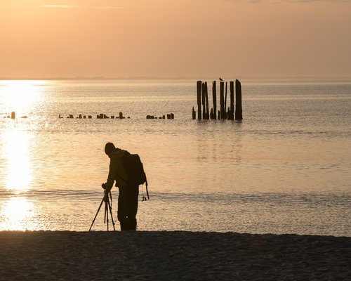 Man taking a relaxing walk along the Danube river at sunset